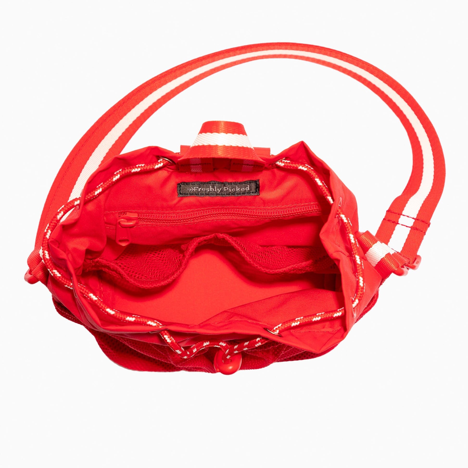 Overhead view of the Cherry Motion Bucket Crossbody bag in red, showing the interior pockets.