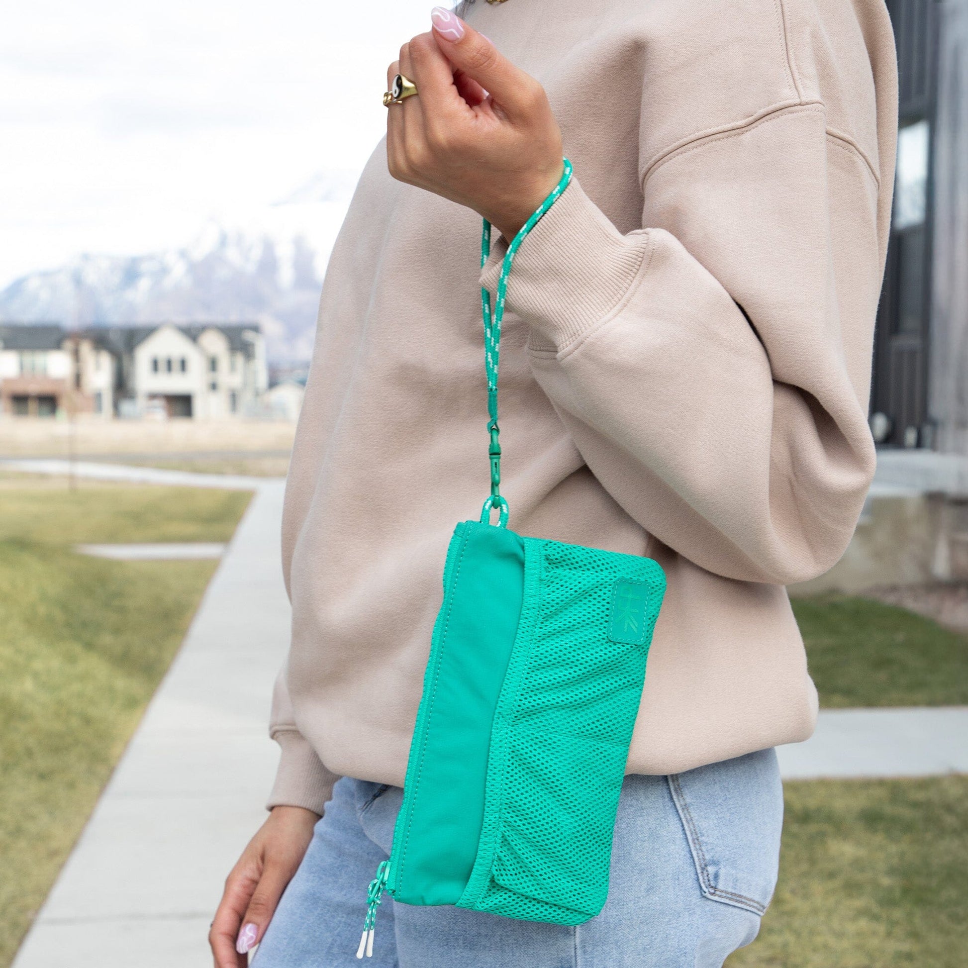 Kelly Motion Wristlet Pouch in green with mesh pockets and wrist strap.