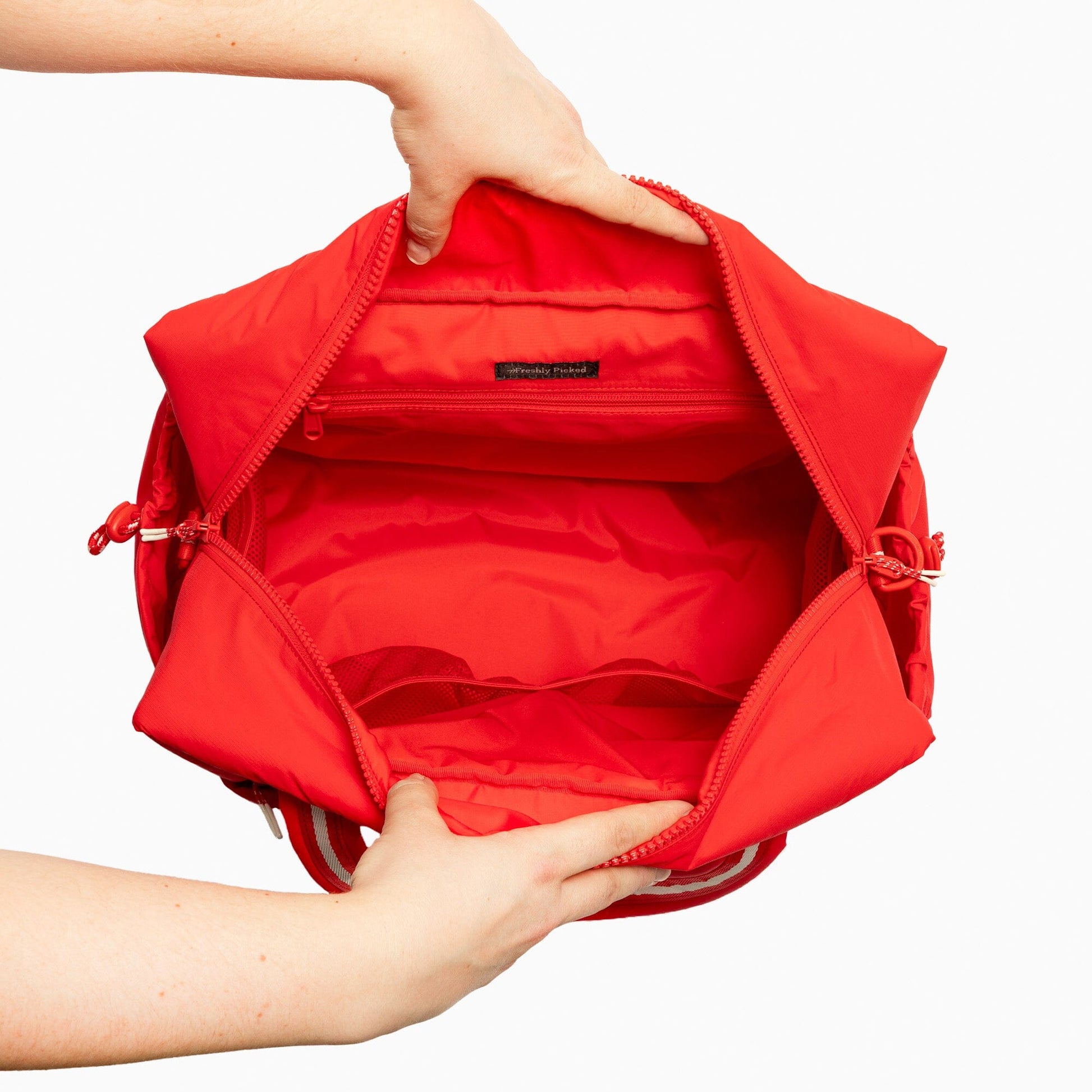 Interior view of the Cherry Motion Overnight Duffle in red, showing pockets.
