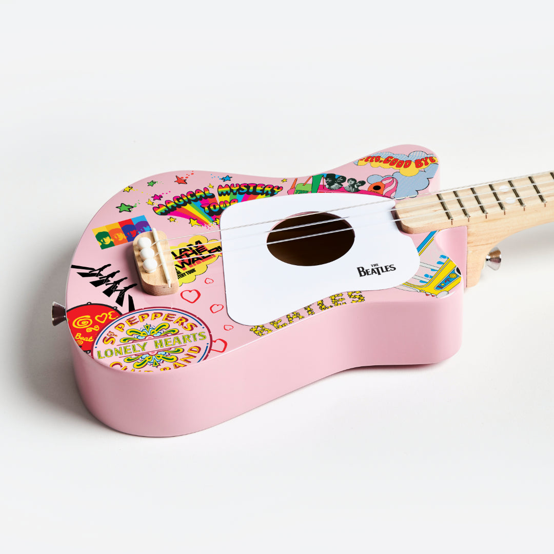 Angled view of pink Beatles Loog Mini Guitar showing details and Beatles logo.