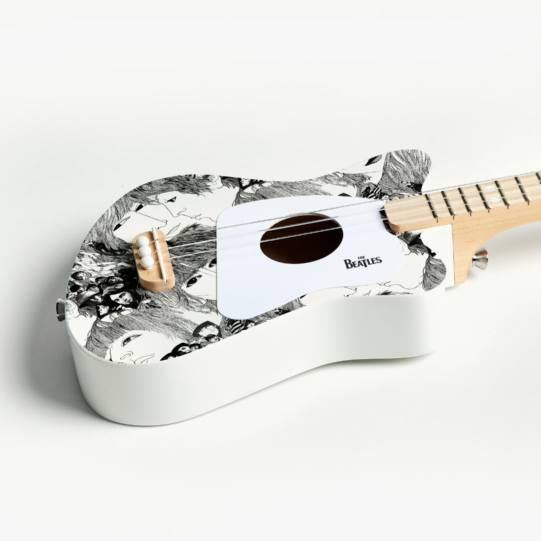 Angle view of The Beatles Loog Mini guitar with character design.