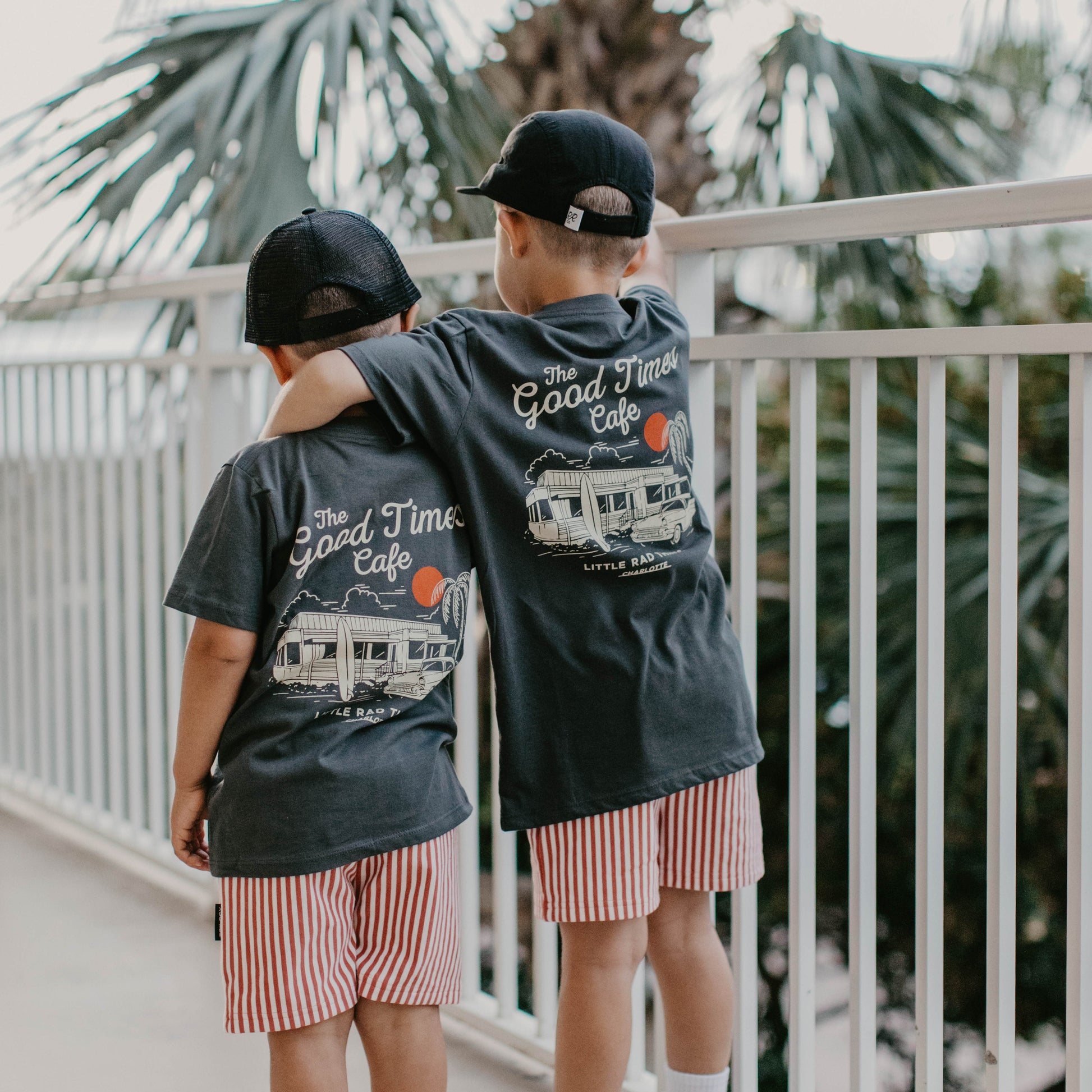 Three boys wearing The Good Times Cafe Tee with matching shorts and hats.