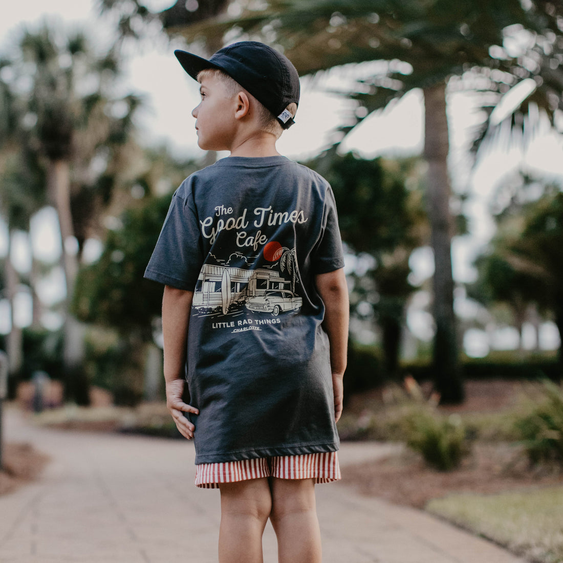 Boy wearing The Good Times Cafe Tee with a cool graphic on the back.