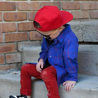 Boy in blue and red plaid Kids Fast and Free Flannel with jeans and red sneakers