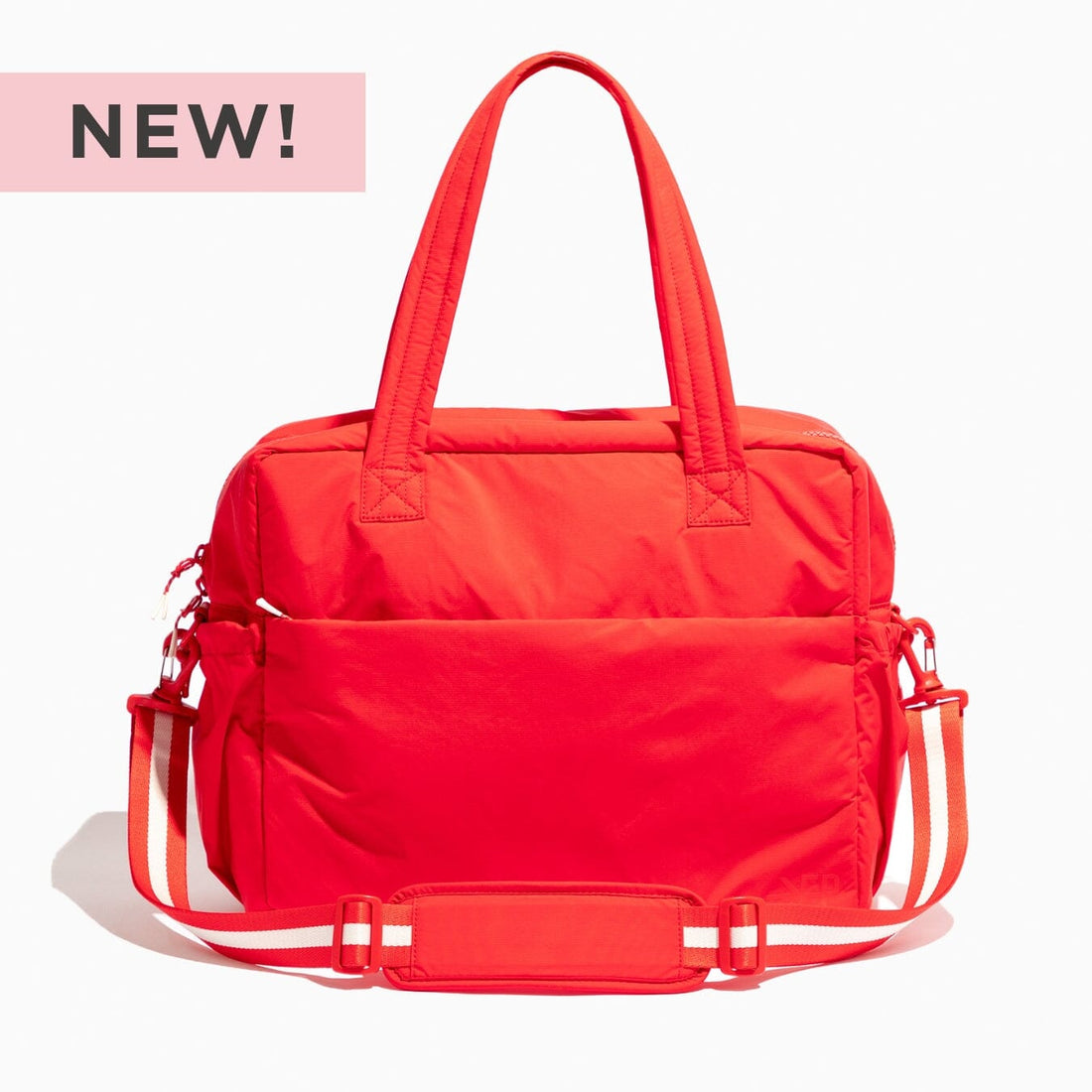 Cherry Motion Overnight Duffle bag in bright red with crossbody strap and top handles.