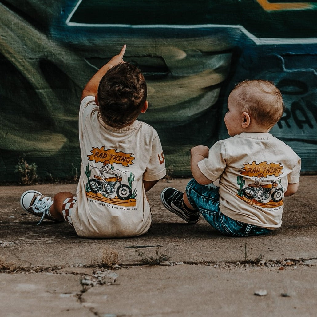 Toddler boy wearing 'Where the Rad Things Are' graphic tee.