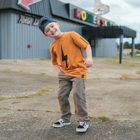 Boy in Pumpkin Spark Tee with Skateboard: A retro-inspired look for active kids.