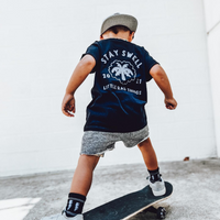 Young boy wearing Stay Swell tee skateboarding