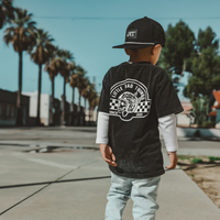 Child wearing black LRT snapback and graphic tee