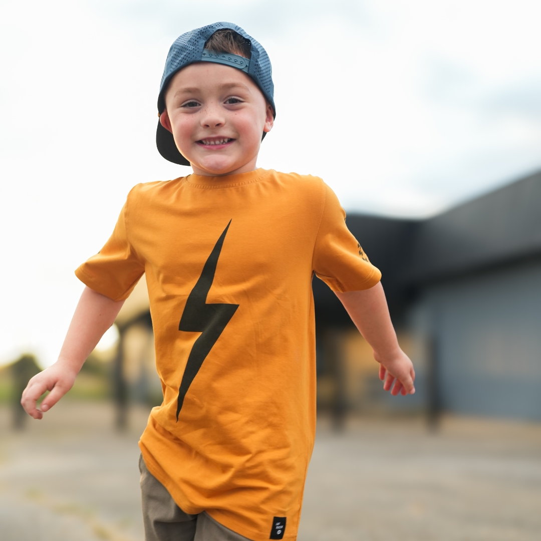 Boy in Pumpkin Spark Tee with Skateboard: A retro-inspired look for active kids.