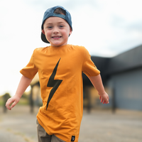 Boy in Pumpkin Spark Tee with Skateboard: A retro-inspired look for active kids.