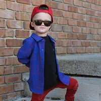 Boy in blue and red plaid Kids Fast and Free Flannel with jeans and red sneakers