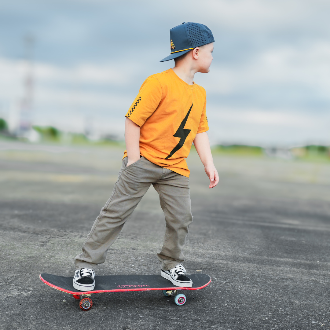 Boy in Pumpkin Spark Tee skateboarding: A vintage-inspired tee for adventurous boys.