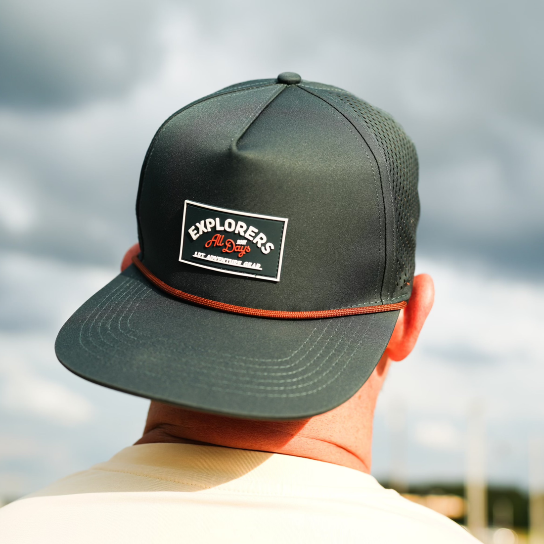 Close-up of Juniper Green Explorer Snapback Hat worn outdoors.