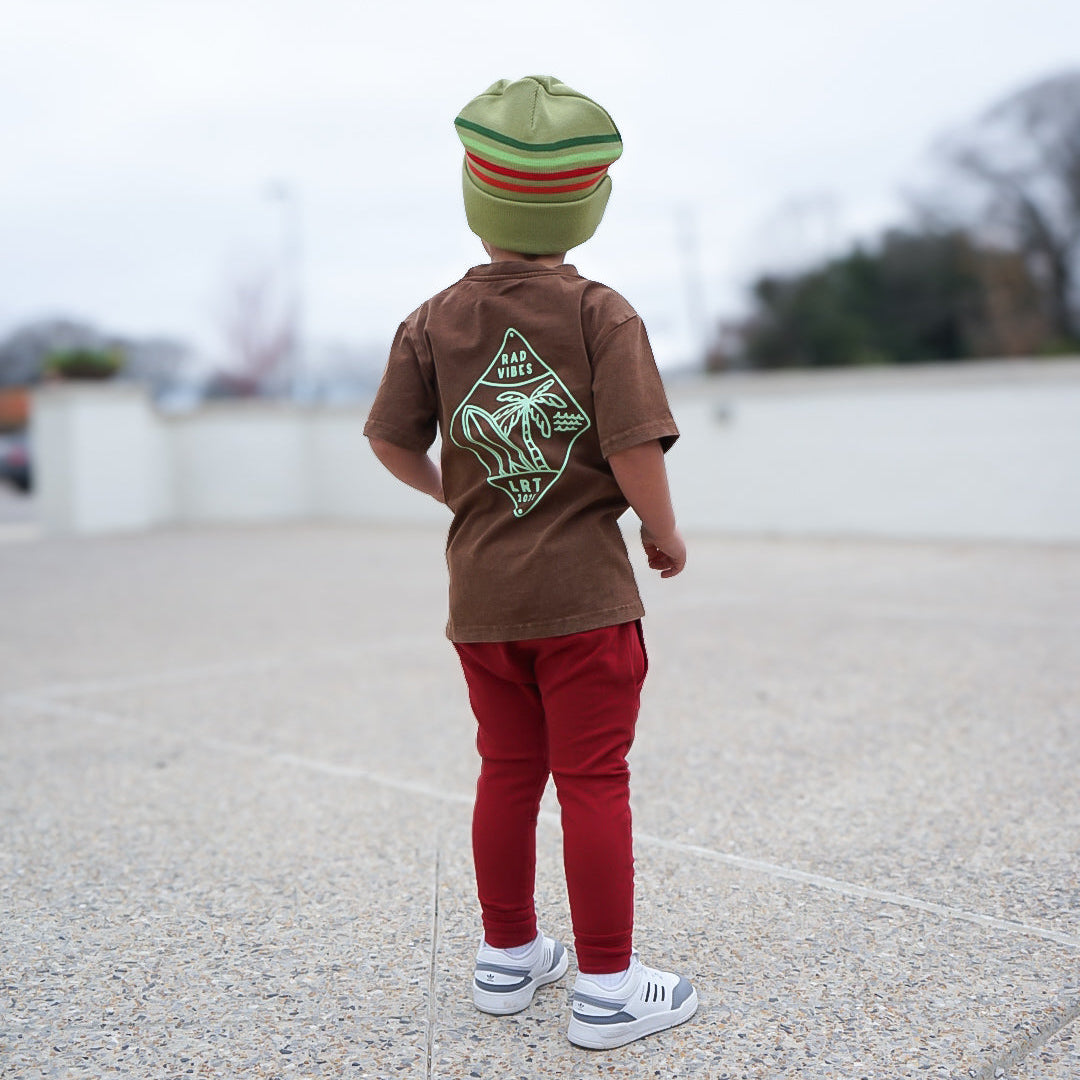 Boy wearing Cocoa Beach Tee, back view, outdoor setting.