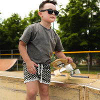 Boys 'Check Ya Later' drawstring shorts in a black, grey, and white checkered pattern.