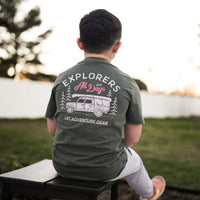 Child in sage green Explorer tee with adventure graphic.