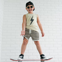 Toddler boy with lollipop wears greige Spark Muscle Tank