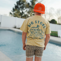 Boy in yellow beige Cloudbreak Tee with 'Big Stoke' graphic near pool.