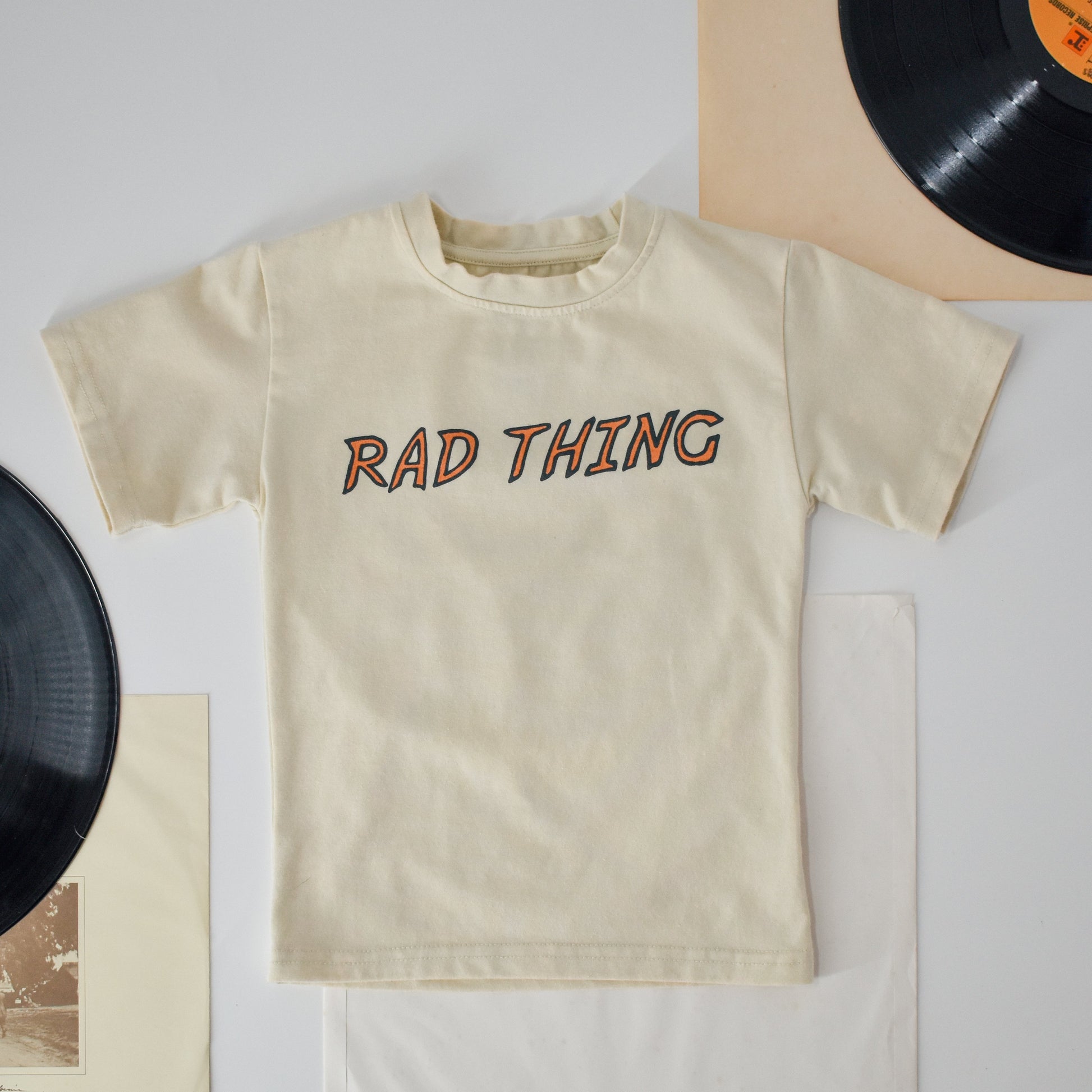 Close-up of the 'Where the Rad Things Are' tee in vintage beige with motorcycle graphic.