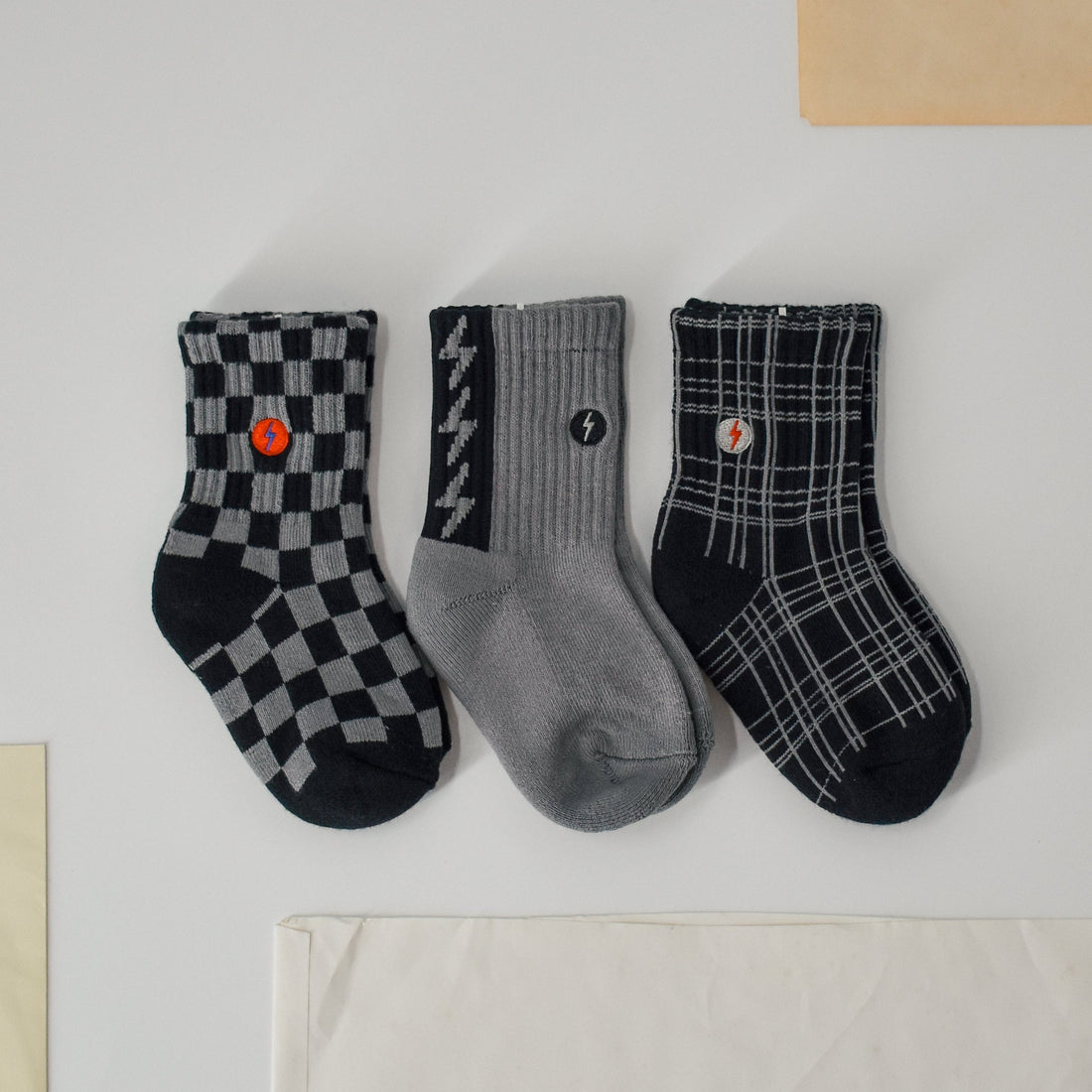 3-pack of Check The Volts socks: checkered, lightning bolt, and plaid designs.