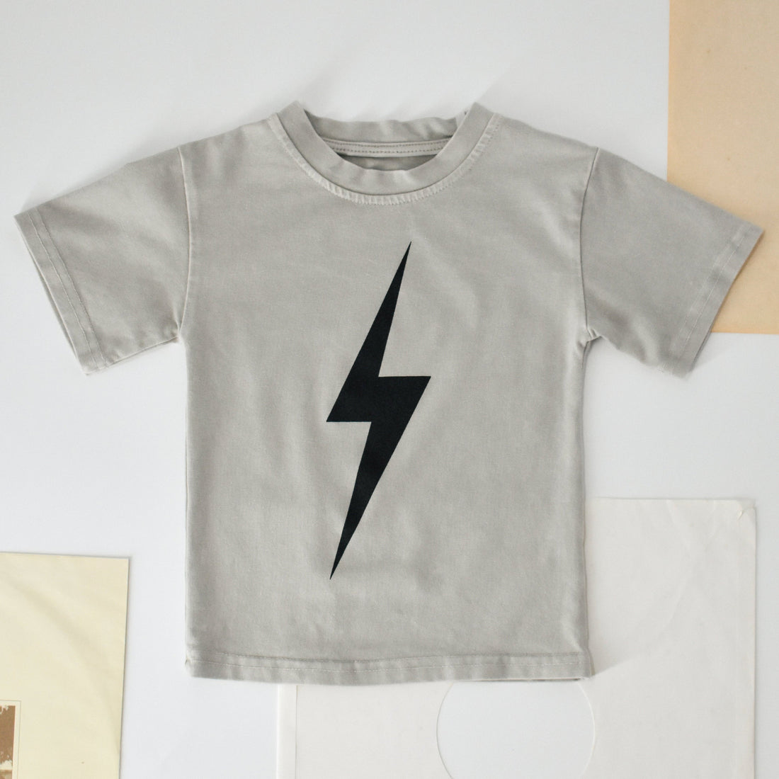 Greige acid wash Spark Tee with bold black lightning bolt design