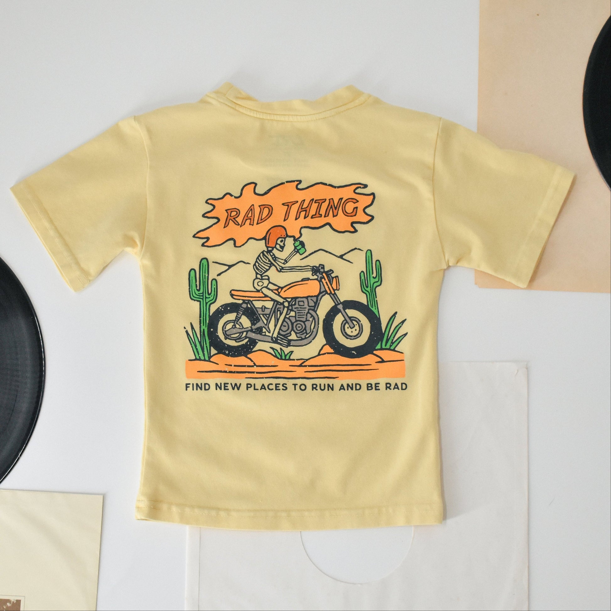 Golden Yellow 'Where the Rad Things Are' tee with motorcycle skeleton graphic.