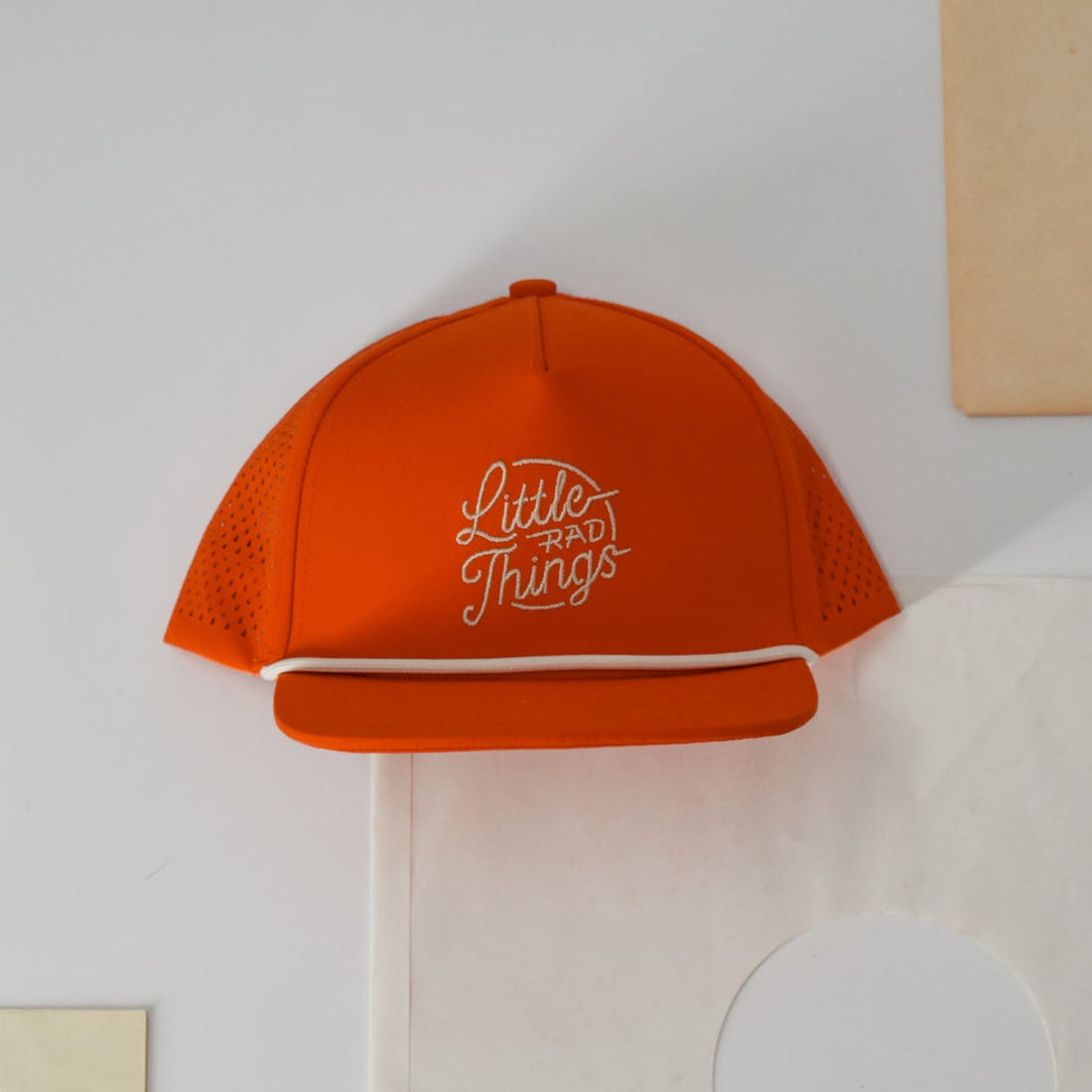 Orange Crush snapback hat with white retro logo, laser-cut design for breathability.