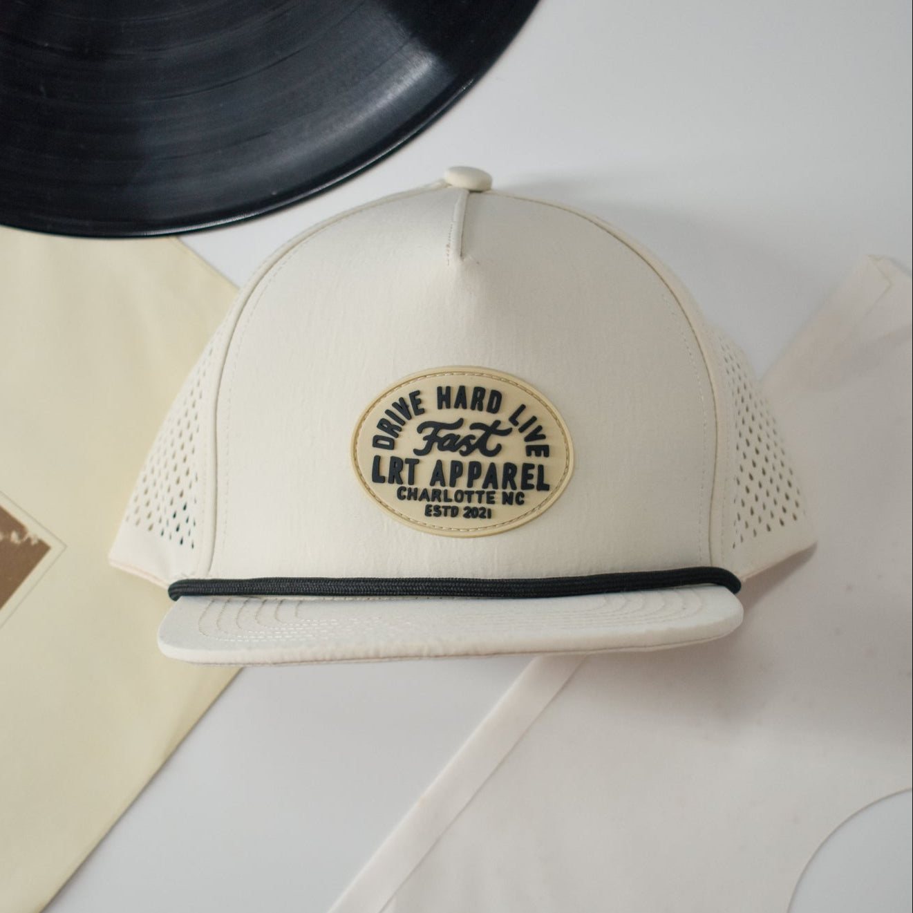 Cream Apex waterproof snapback hat with laser-cut ventilation and curved bill.