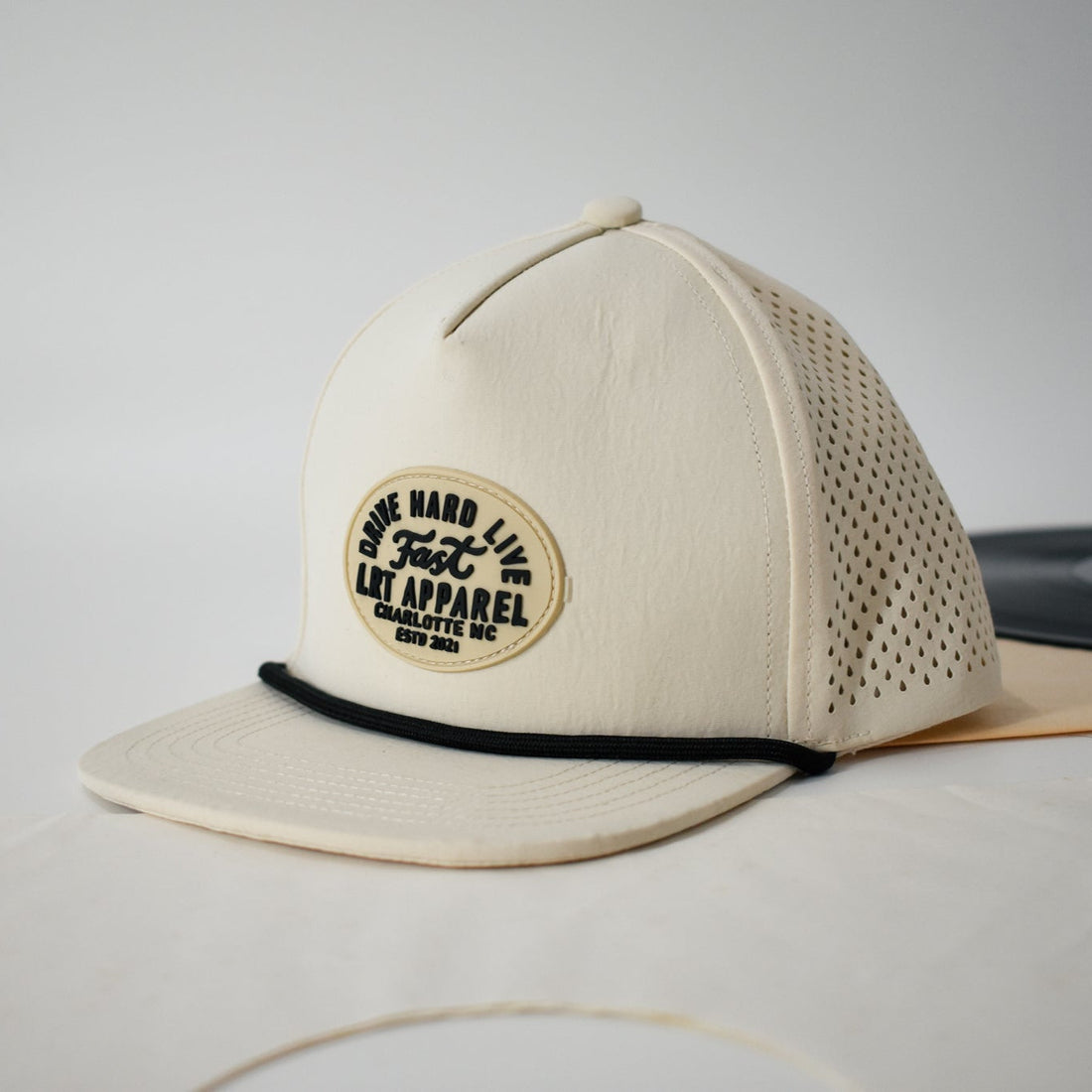 Cream Apex waterproof snapback hat with laser-cut ventilation and curved bill.
