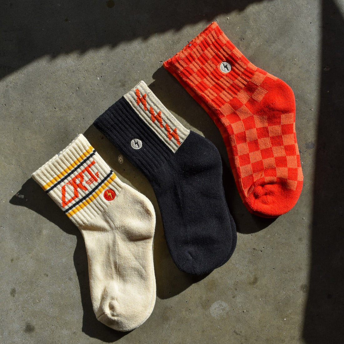Retro kids socks: vintage-inspired designs, soft cotton blend, red/orange check, spark print, LRT logo.