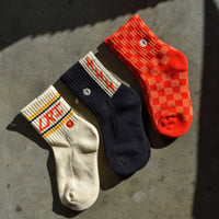 Retro kids socks: vintage-inspired designs, soft cotton blend, red/orange check, spark print, LRT logo.