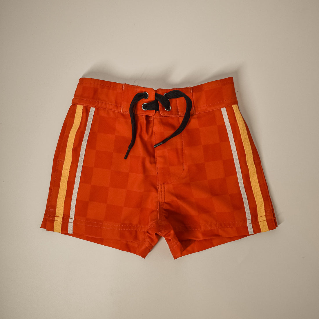 Retro-wave hybrid board shorts in red/orange checkerboard pattern.