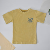 Close-up of yellow beige Cloudbreak Tee with 'Big Stoke' wave design. 