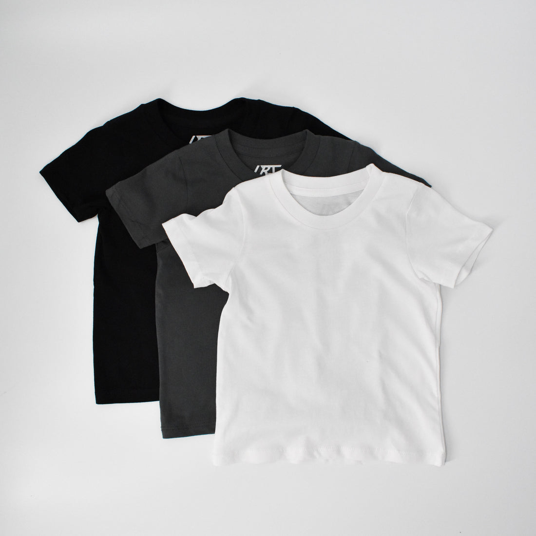 Rad Organics monochrome tee 3-pack, black, grey, and white shirts.
