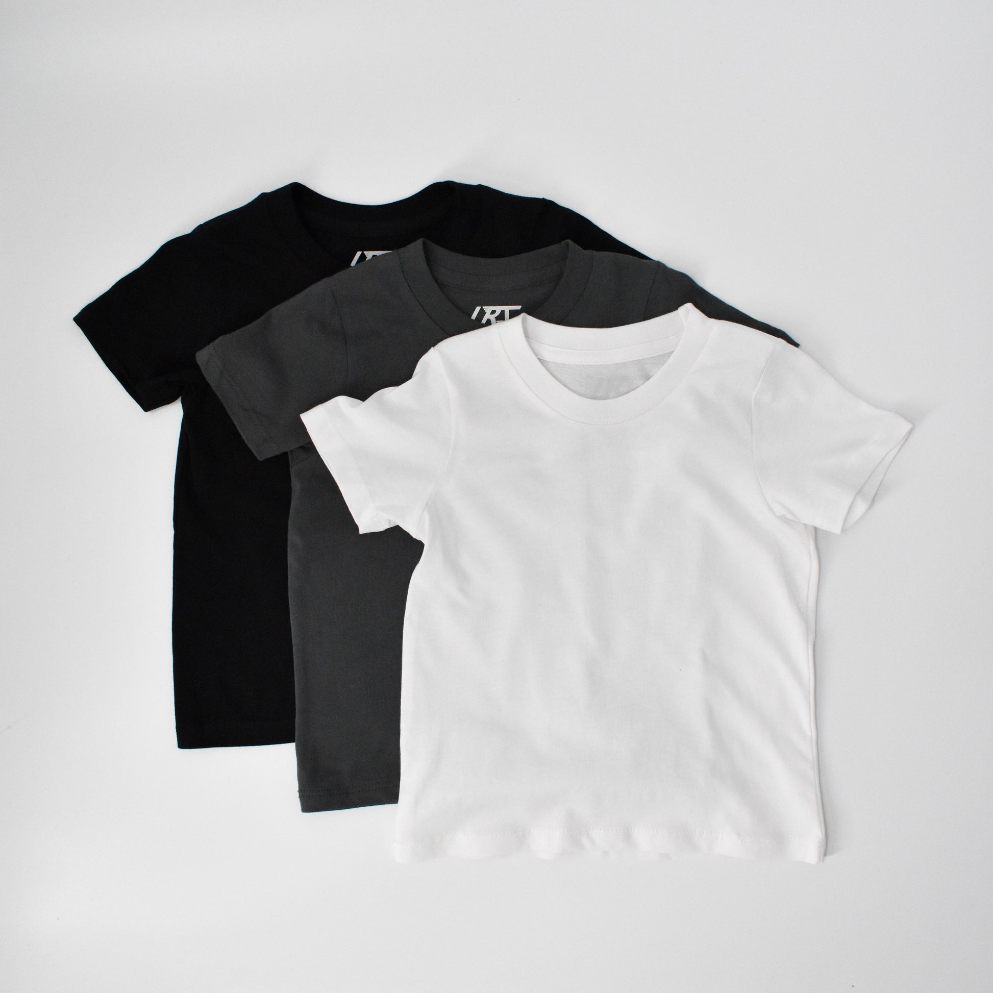 Rad Organics monochrome tee 3-pack, black, grey, and white shirts.
