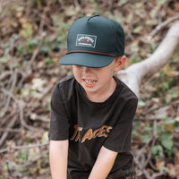 Boy wearing Juniper Green Explorer Snapback Hat and 'The Aces' t-shirt.