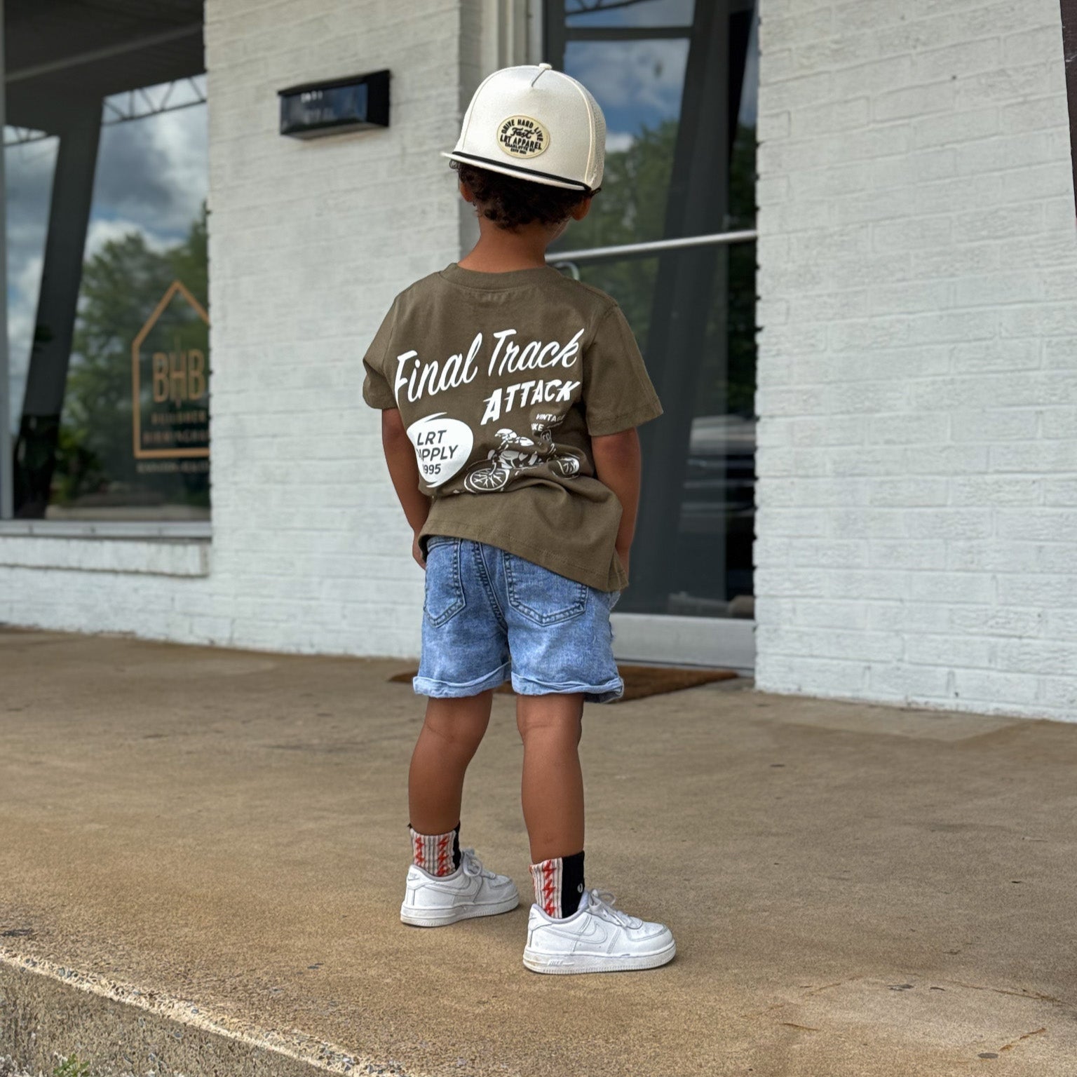 Child in USA-made military green Final Track Attack Tee with motorcycle design.