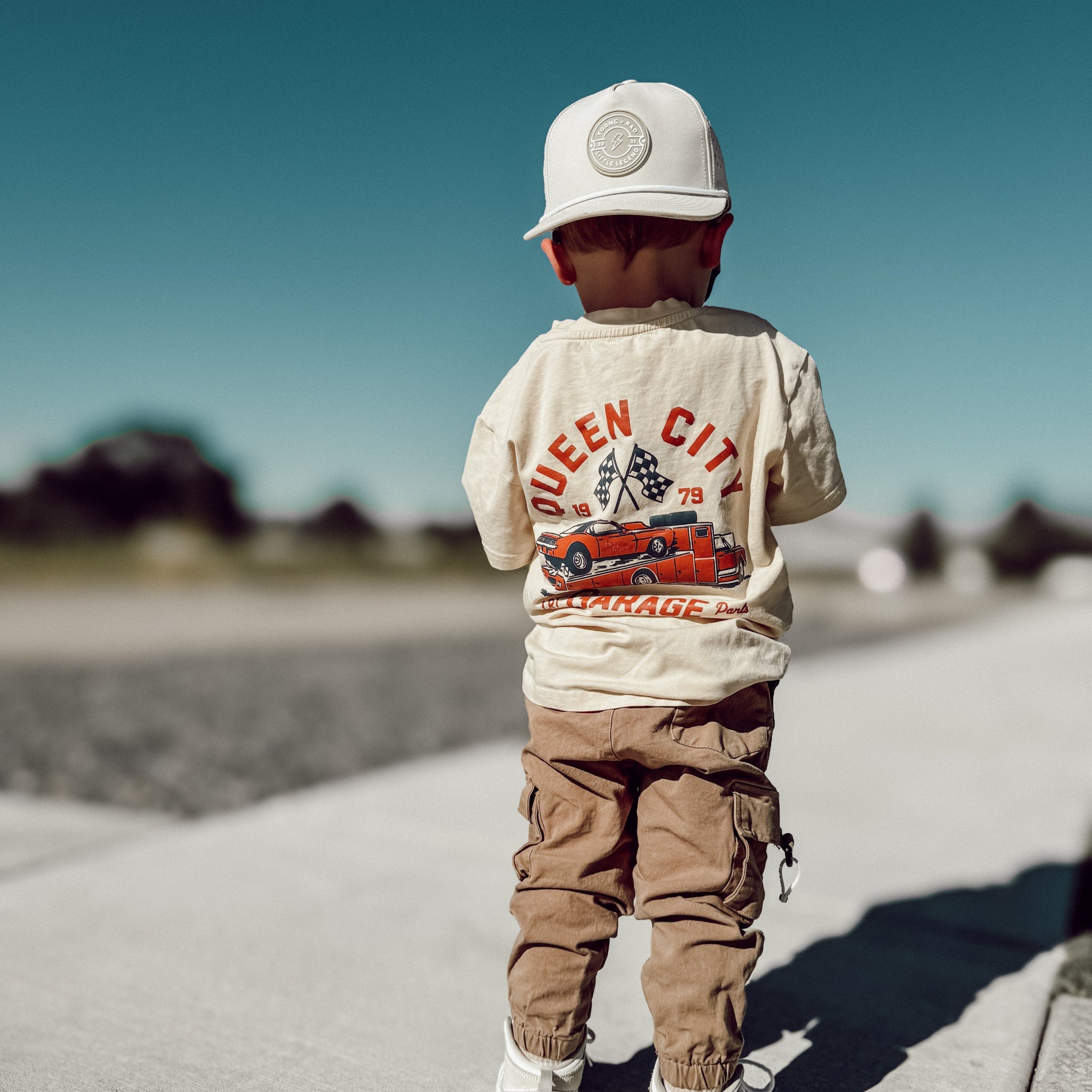 Young boy wearing Queen City Garage Tee with racing graphic.