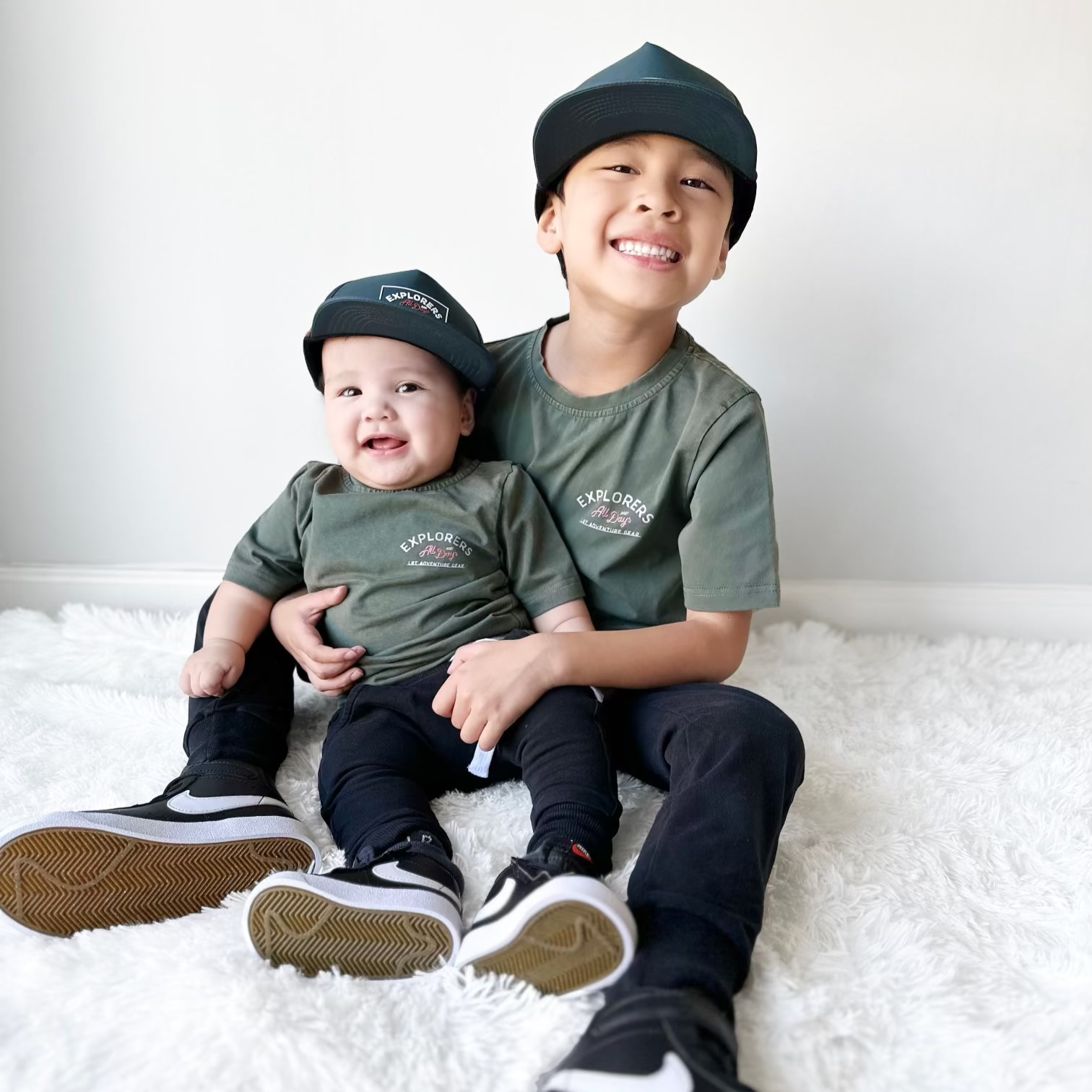 Child in sage green Explorer tee with adventure graphic.