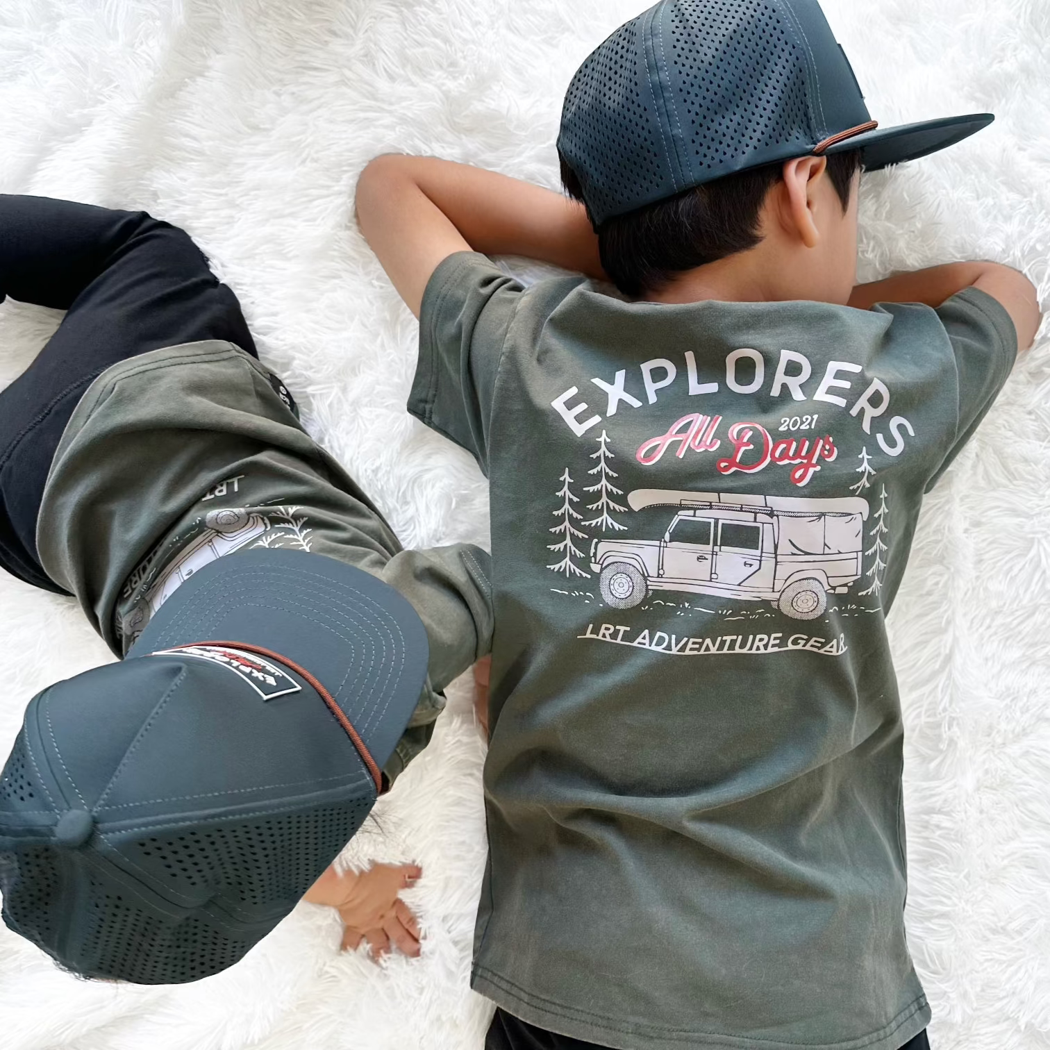 Boys in matching sage Explorer tees and hats.