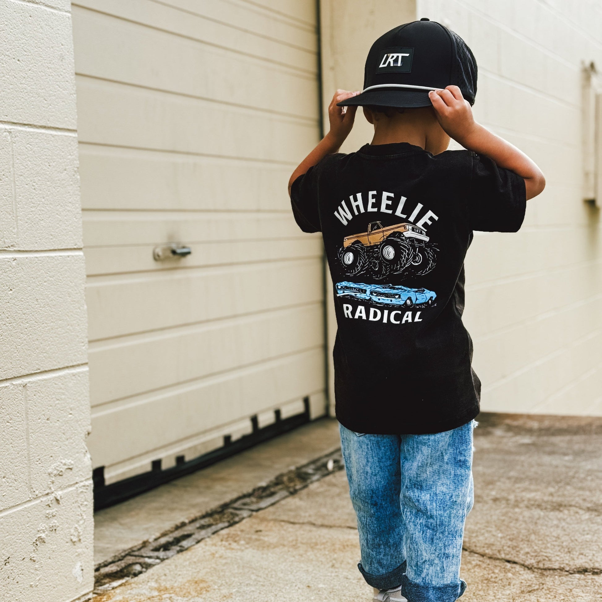 Boy in jeans and Wheelie Radical Tee with retro monster truck graphic