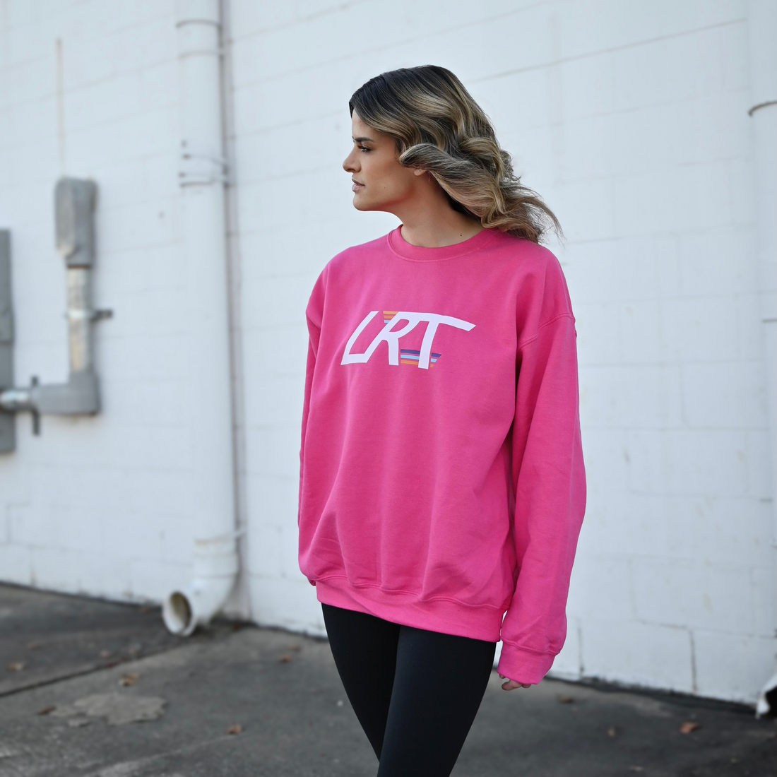 Woman wearing a pink LRT Winged Logo Crew Sweatshirt.