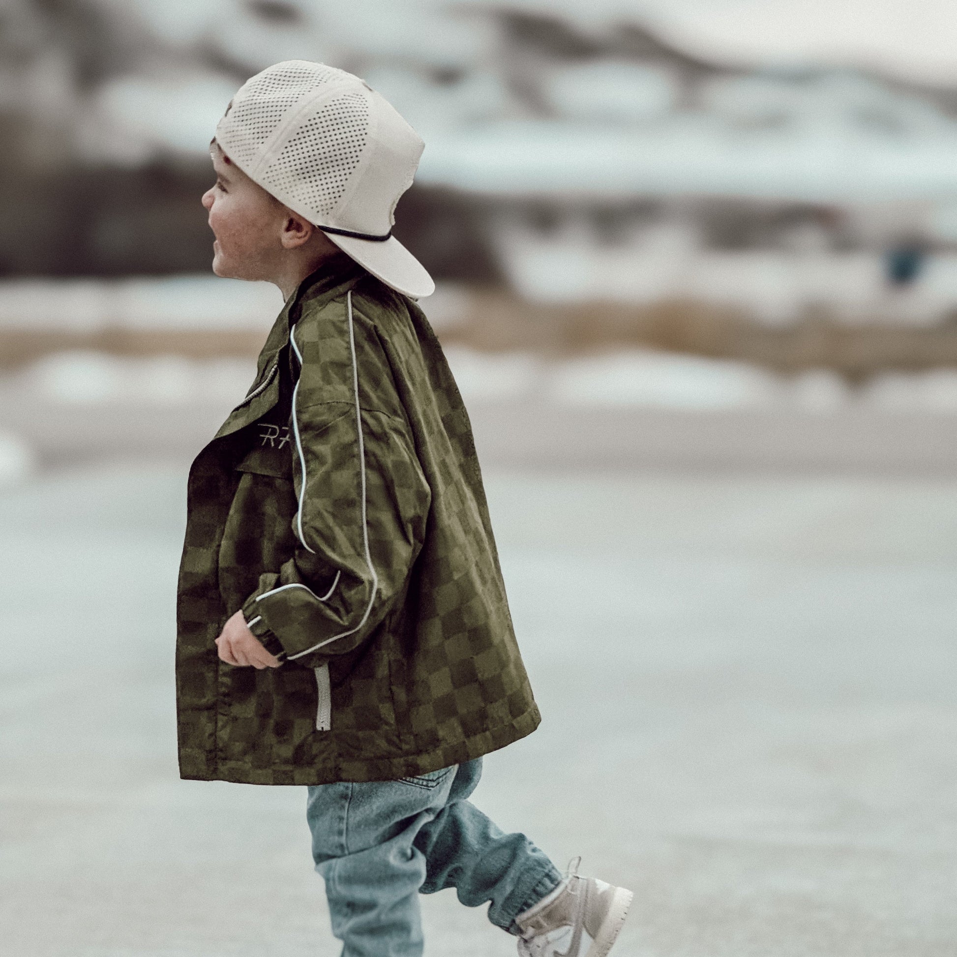 Army green Storm Rider waterproof jacket with subtle checkerboard pattern.