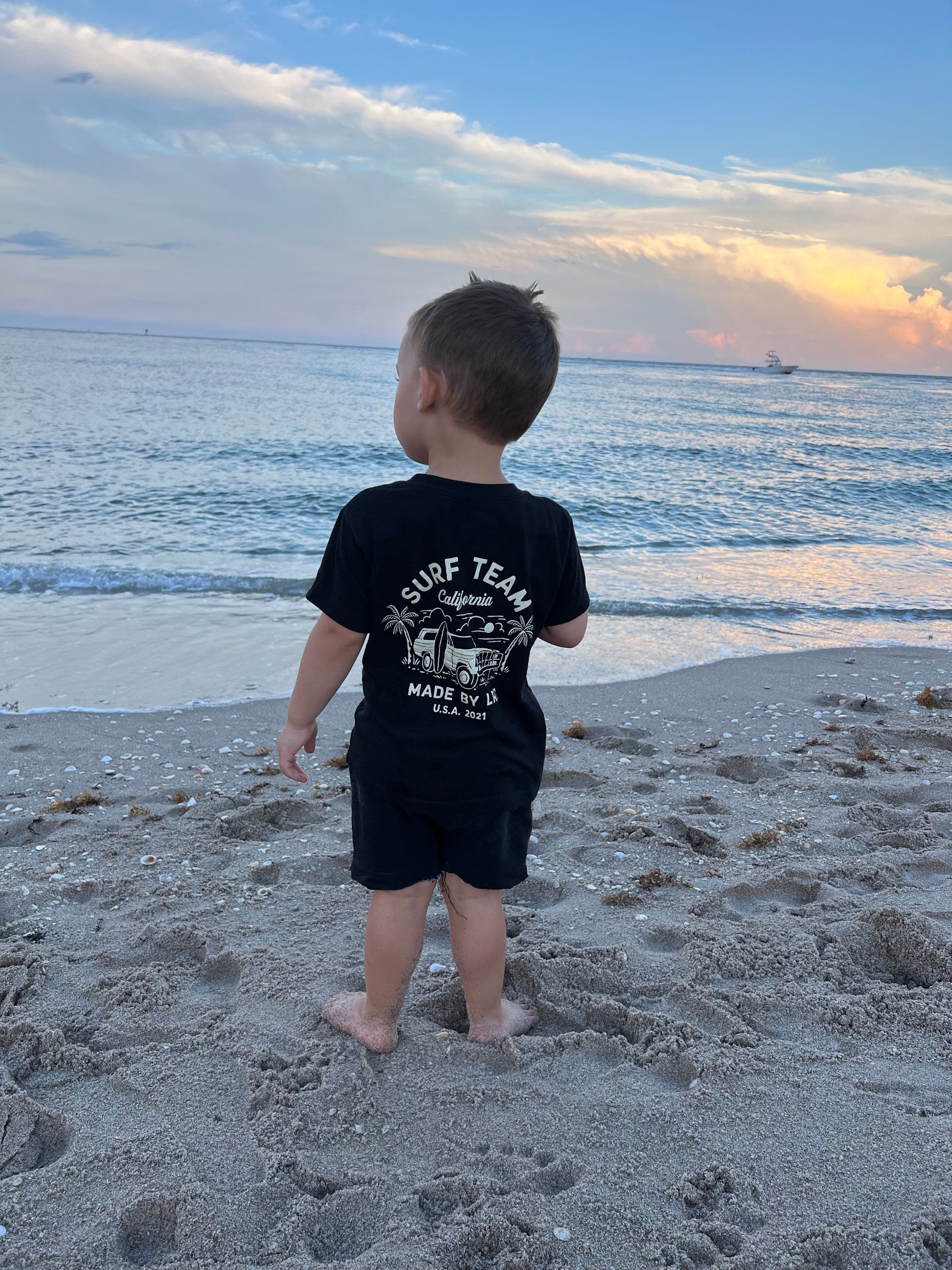 Child skateboarding in blue Surf Team tee and jeans.