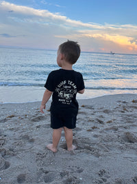 Child skateboarding in blue Surf Team tee and jeans.