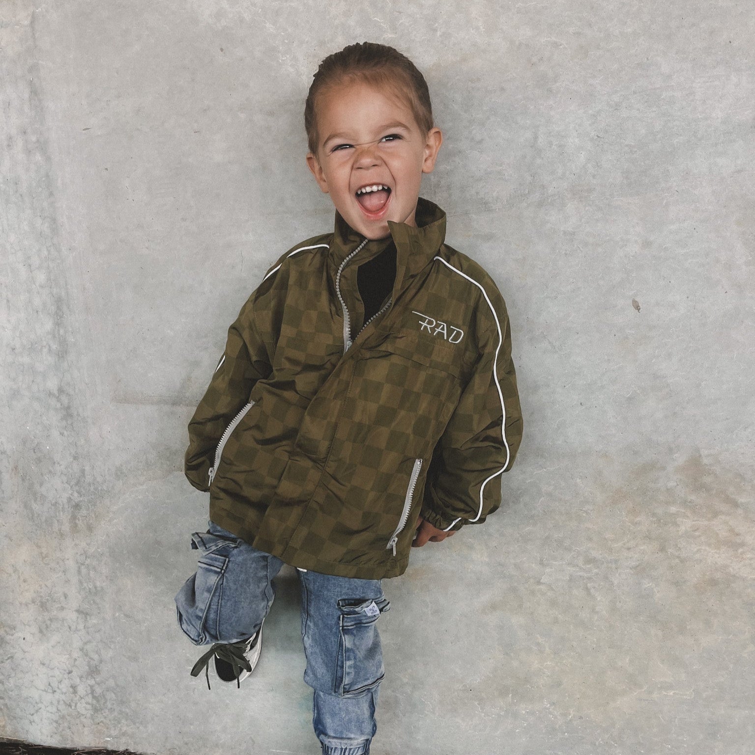 Army green Storm Rider waterproof jacket with checkerboard pattern.