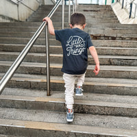Boy wearing smoke RAD CIRCLE LOGO TEE climbing stairs.