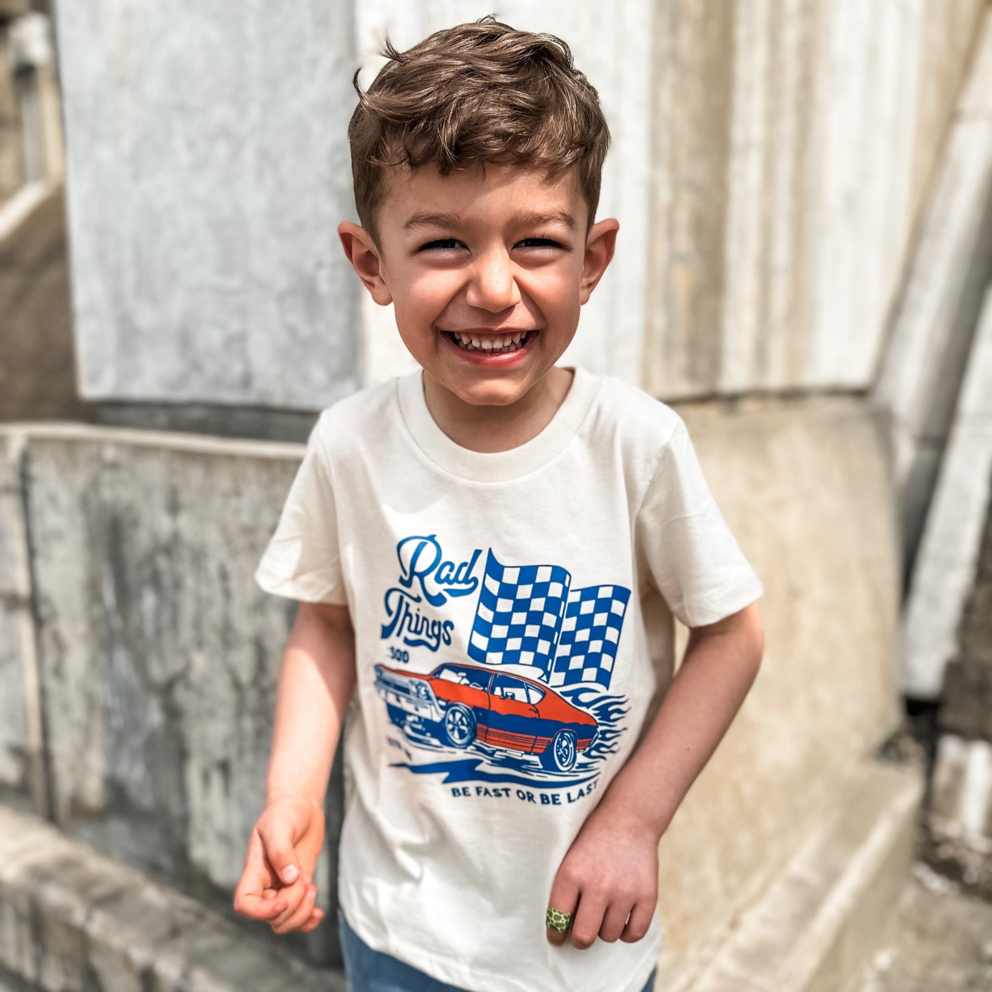 Smiling boy in Rad Things 500 natural cream graphic tee.