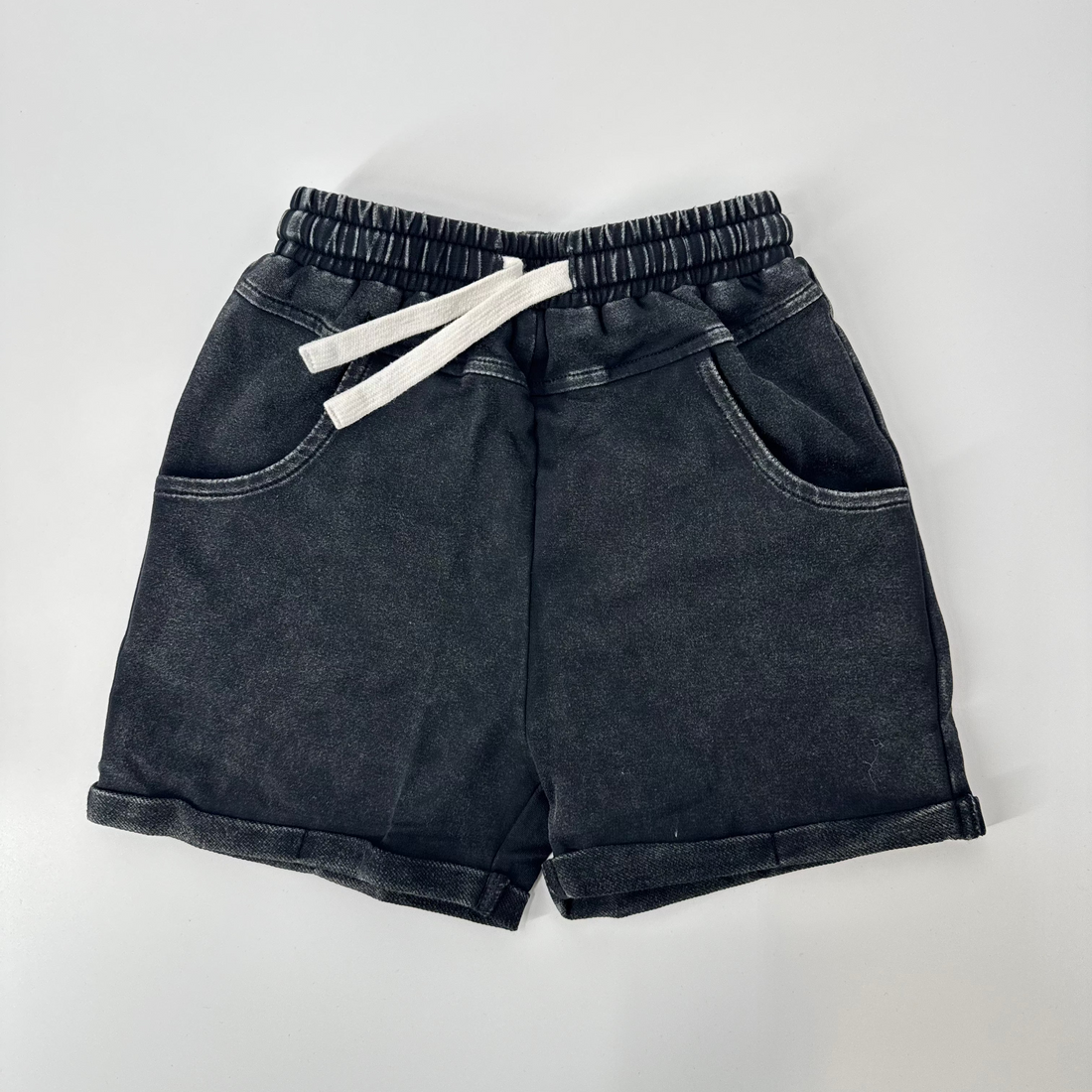 Black vintage wash shorts with drawstring waist and rolled cuffs.